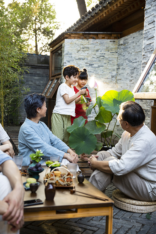 中秋节一家六口在户外庭院聚餐嬉戏玩耍图片下载