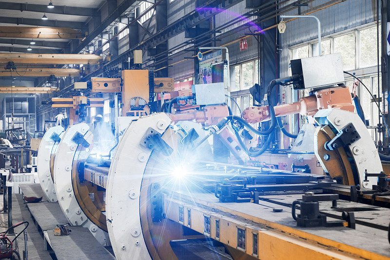 现代化工厂内的焊接机器人图片下载