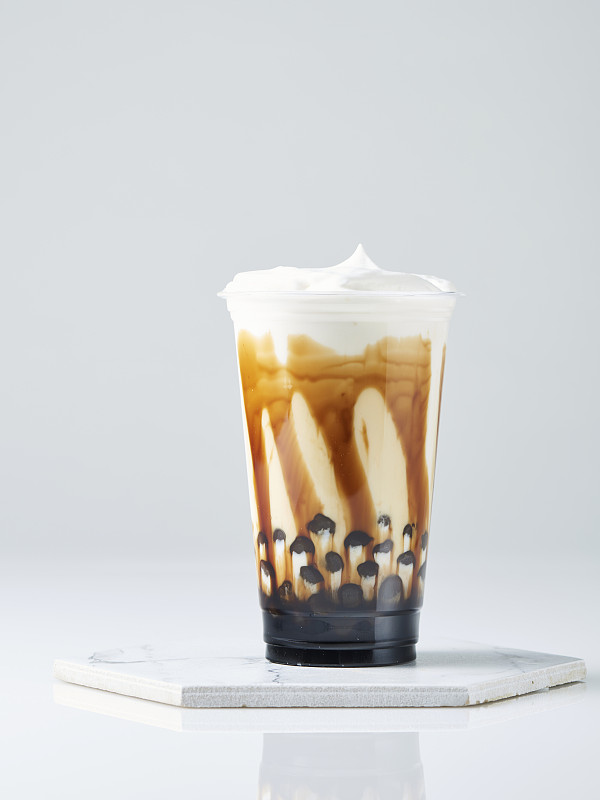 红糖奶茶，木薯珍珠和鲜奶油在白色的背景图片素材