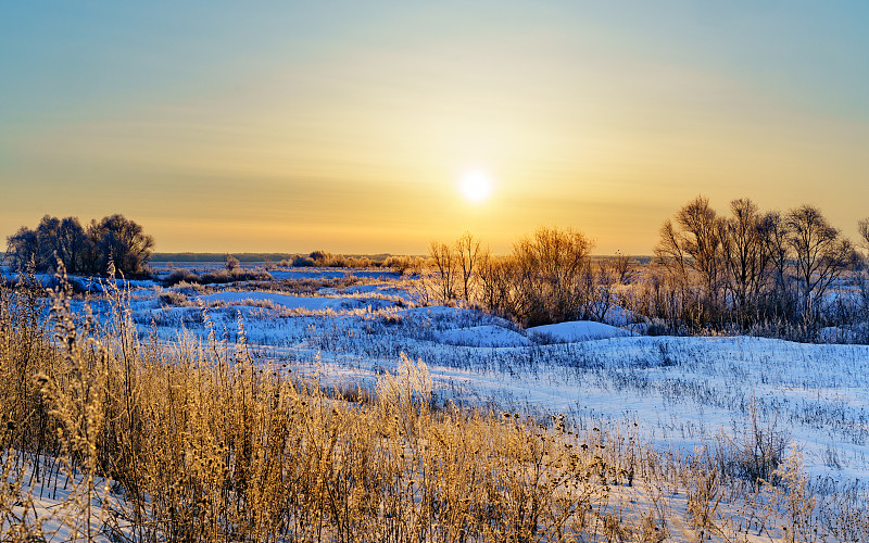 日落时分白雪覆盖的田野景色图片素材