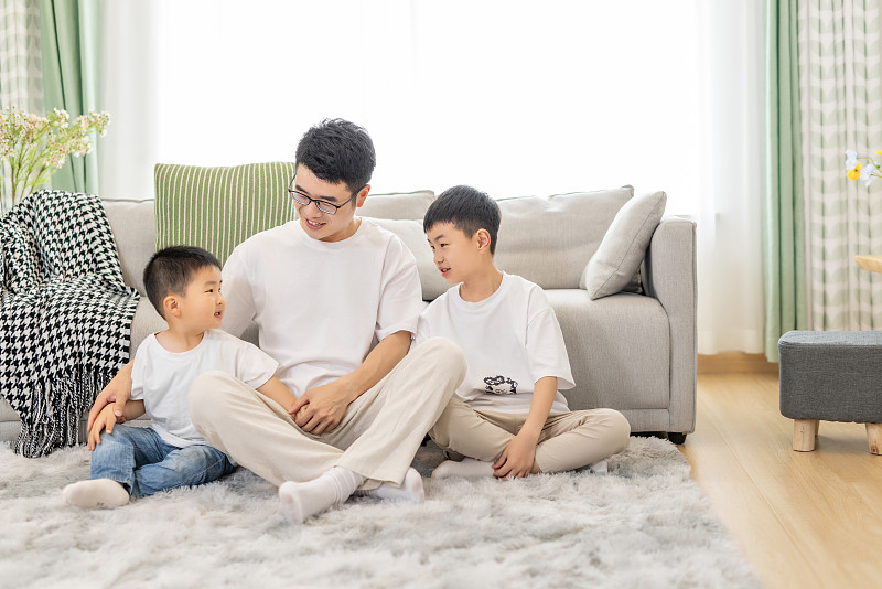 客厅地毯上坐着幸福的亚洲父子三人图片下载