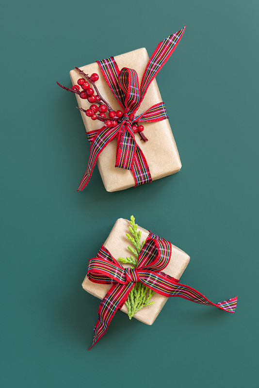 礼盒包装在卡夫卡纸与红色丝带蝴蝶结在绿色顶视图图片下载
