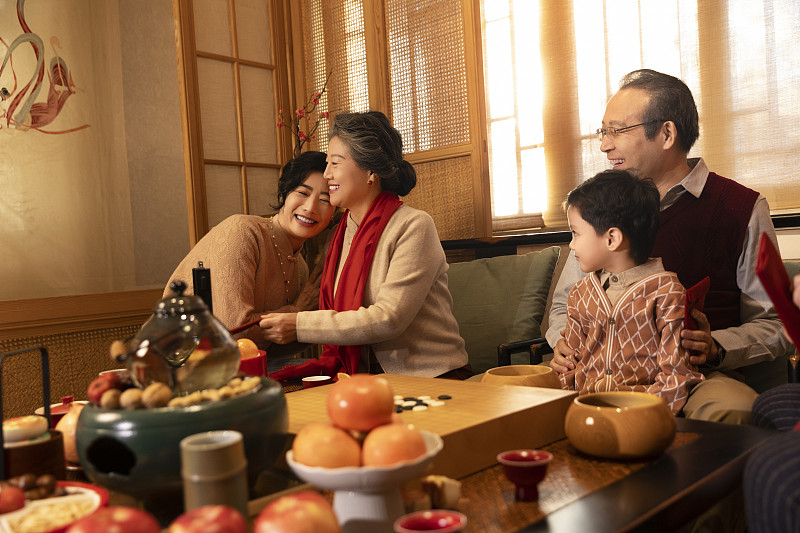 东方家庭过年：幸福一家人在客厅拜年、送压岁红包图片下载