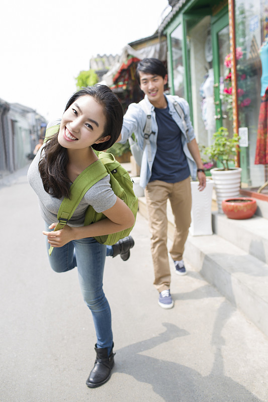 年轻情侣在北京胡同里旅游图片下载