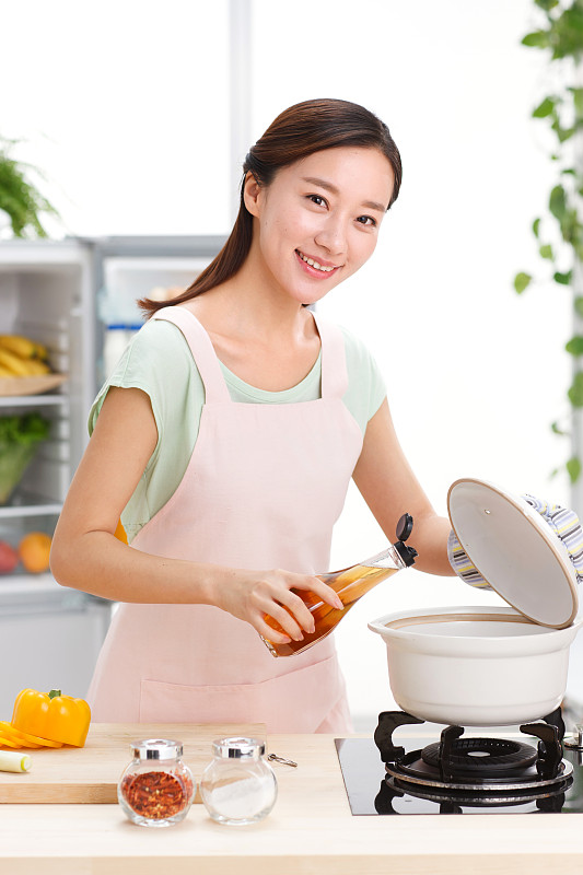 年轻女人在厨房做饭图片下载