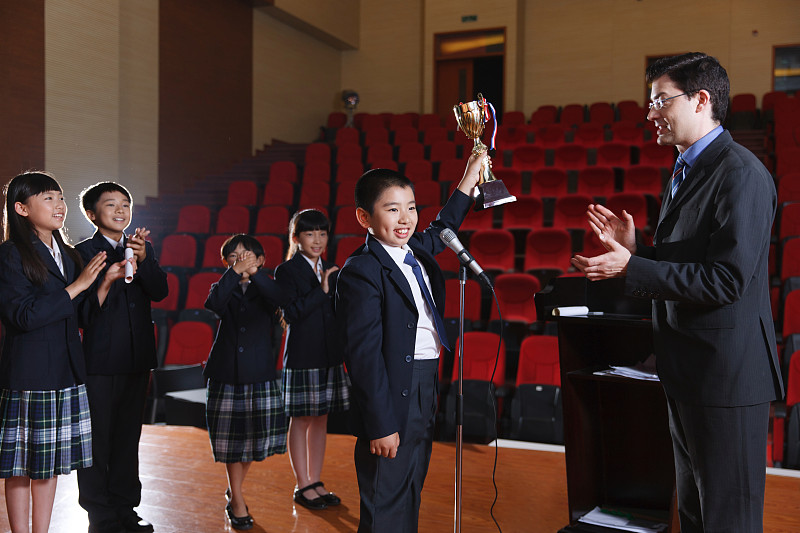 国际小学里的老师和小学生在颁奖台上图片下载