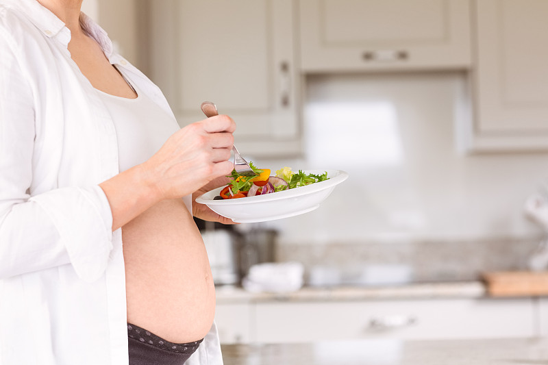 孕妇在家厨房里吃沙拉图片素材