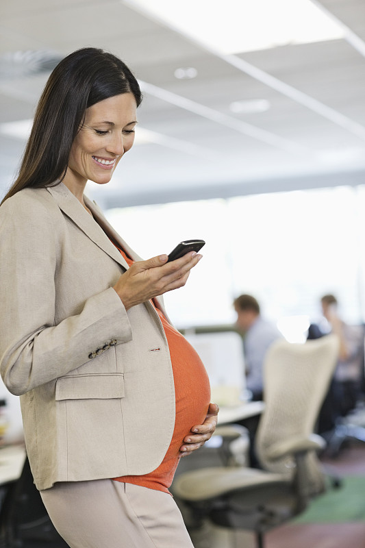 怀孕的女商人使用手机图片素材