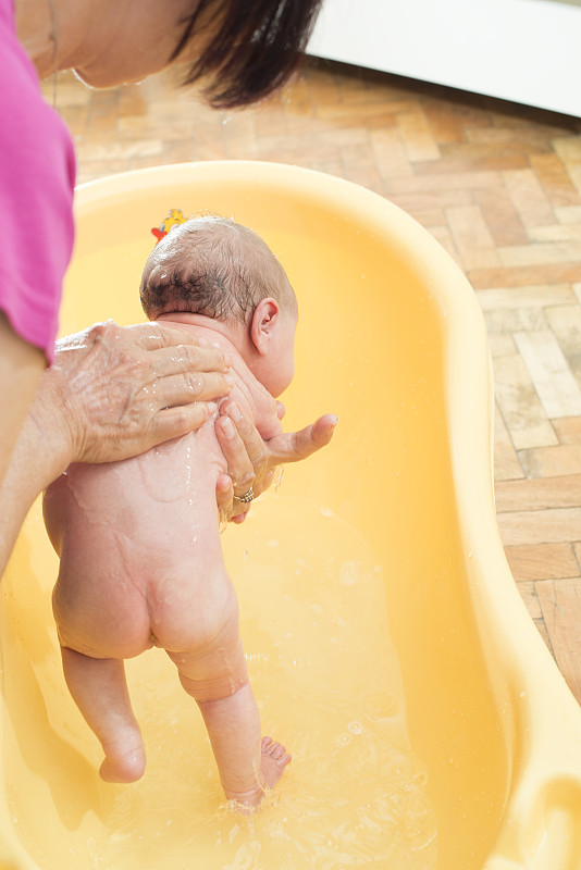 新生儿洗澡。图片素材