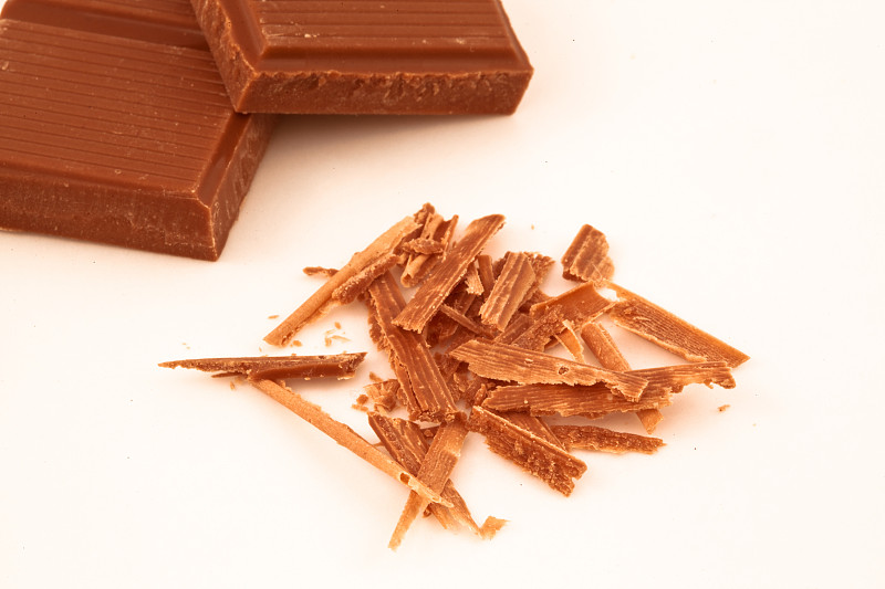 巧克力屑和巧克力块一起放在白色的背景上图片下载