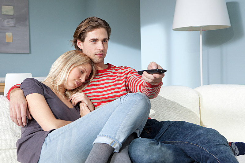 年轻夫妇在看电视，女人在睡觉图片下载
