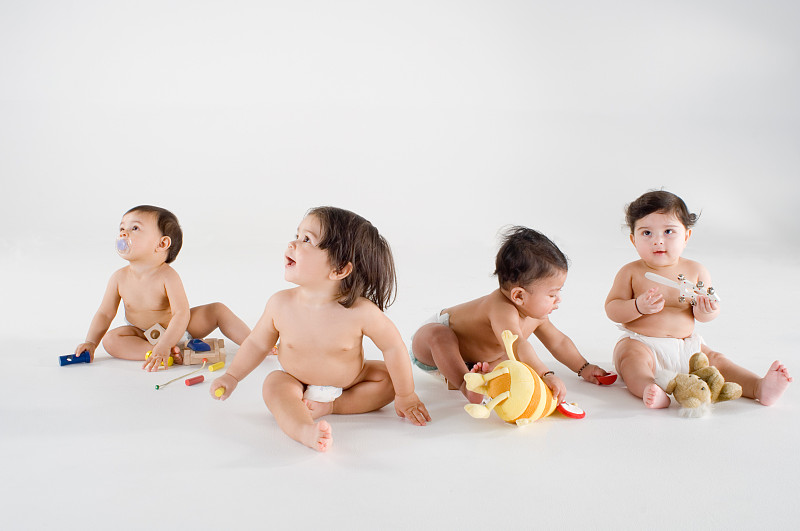 四个婴儿坐着玩玩具图片下载