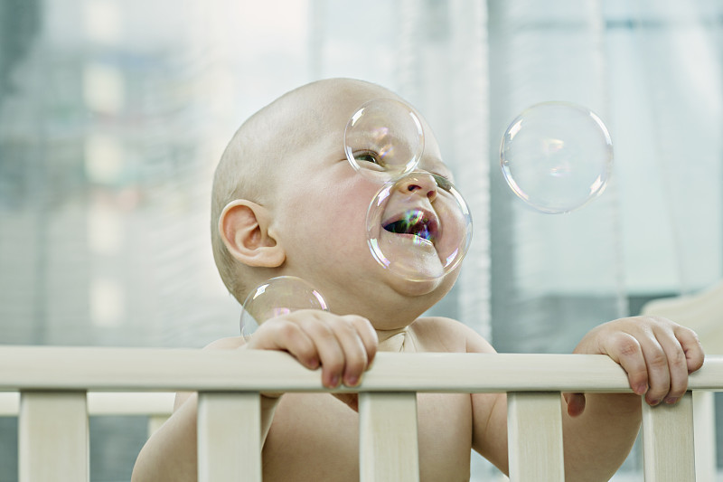 婴儿在婴儿床享受泡沫图片下载