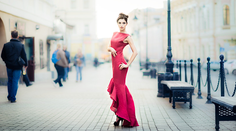 穿着红色衣服的年轻女子在城市街道上图片下载