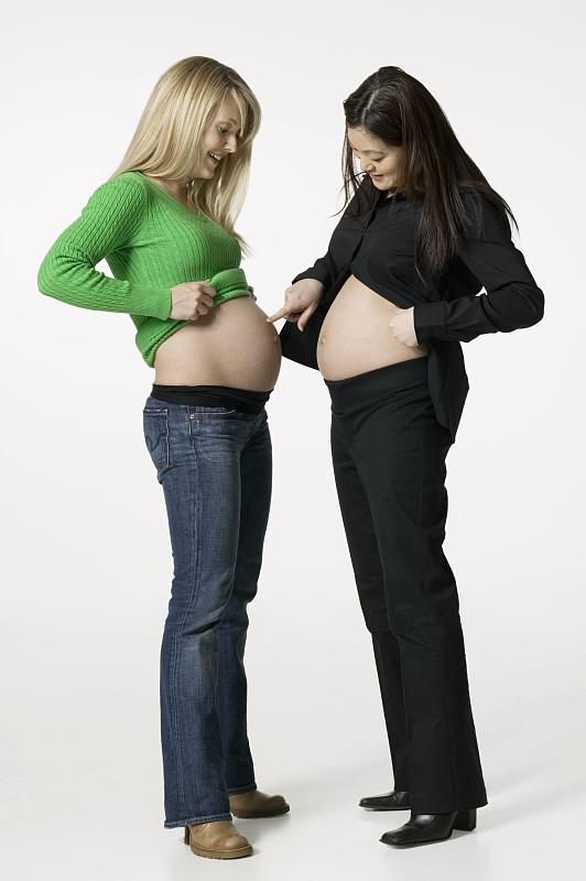 两个孕妇在工作室里比较自己的肚子图片下载