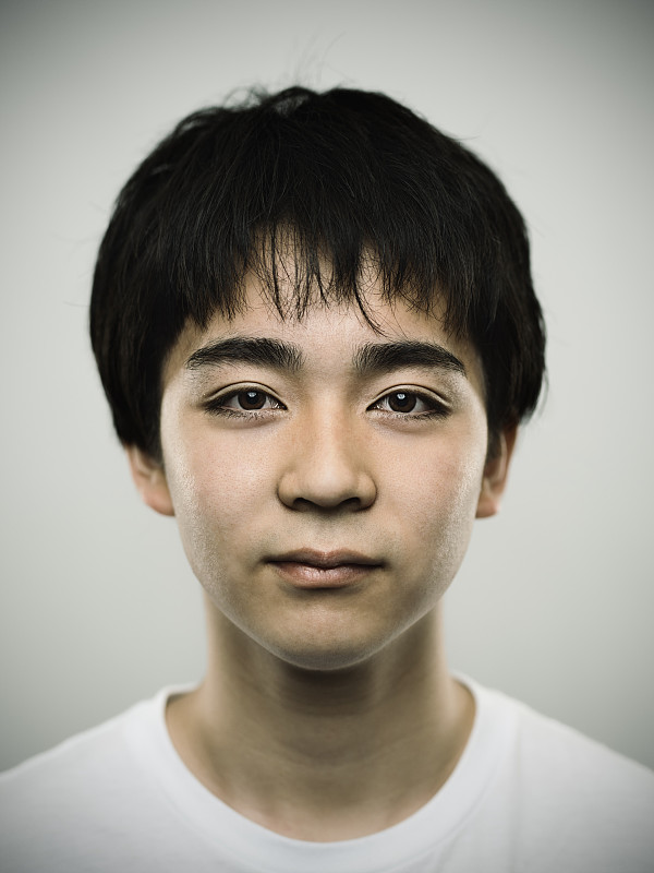 一个日本少年看着相机的肖像图片下载
