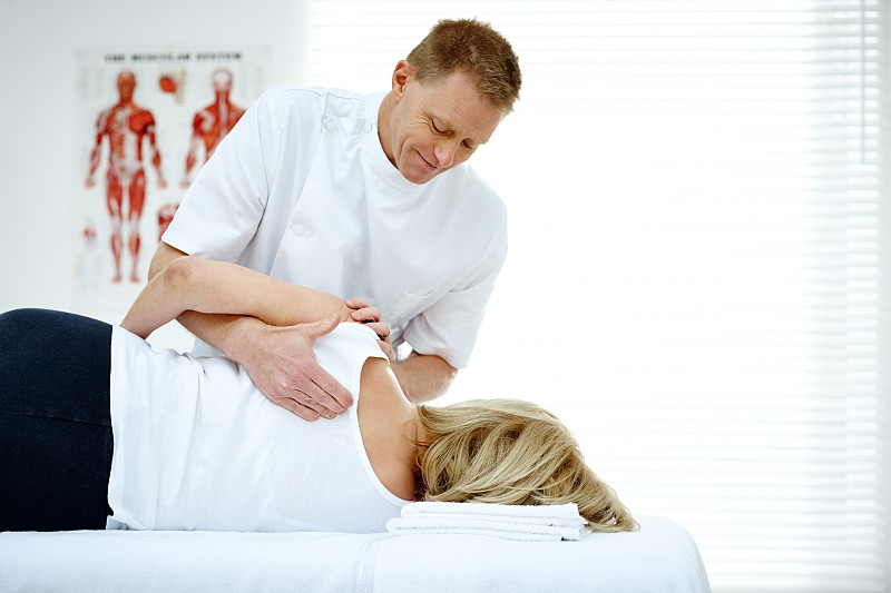 脊椎按摩师按摩女性病人的背部图片素材