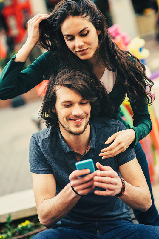 一对年轻幸福的情侣在电话里发短信图片下载