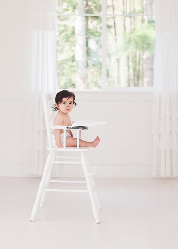 婴儿坐在白色高脚椅上图片下载