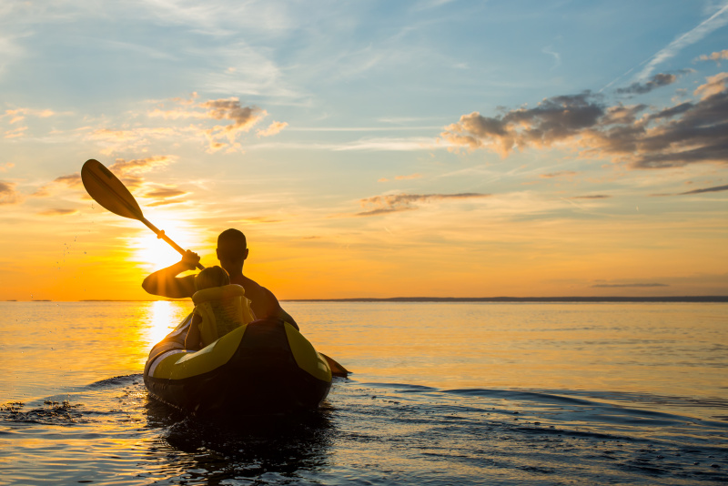 在日落时玩海上皮划艇图片下载