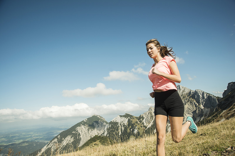 奥地利，蒂罗尔，坦尼姆山谷，年轻女子在山上慢跑图片下载