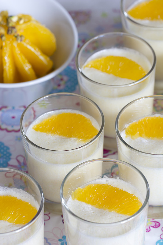 用牛奶、粗麦粉和橙汁盛在玻璃杯里的甜点，用柳橙片装饰图片下载