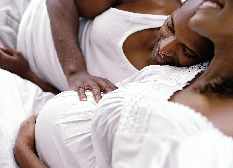 侧面特写一个男人躺在他怀孕的妻子旁边图片下载