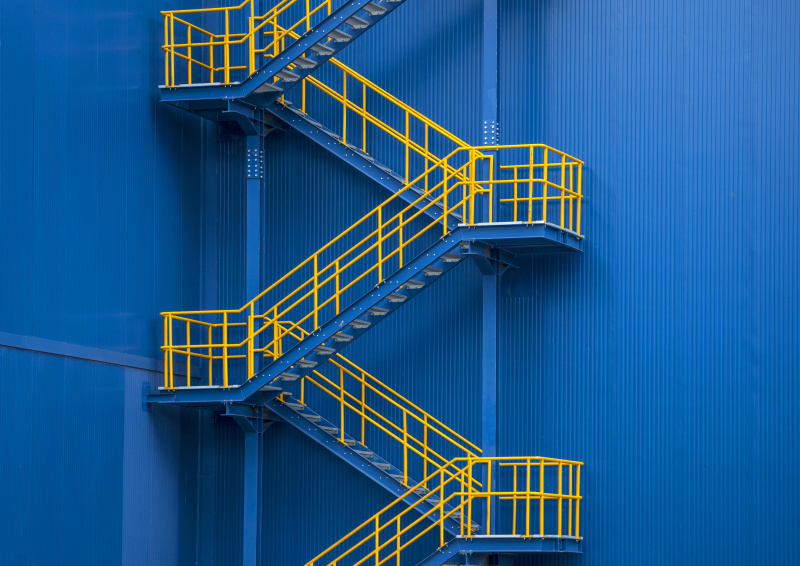 黄色的金属楼梯对着蓝色的墙图片下载