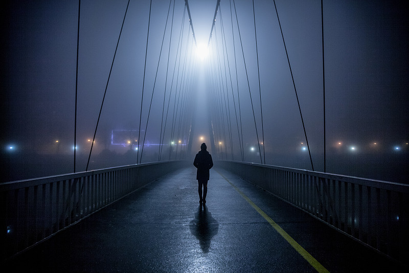 孤独的女人在夜里走过桥图片素材