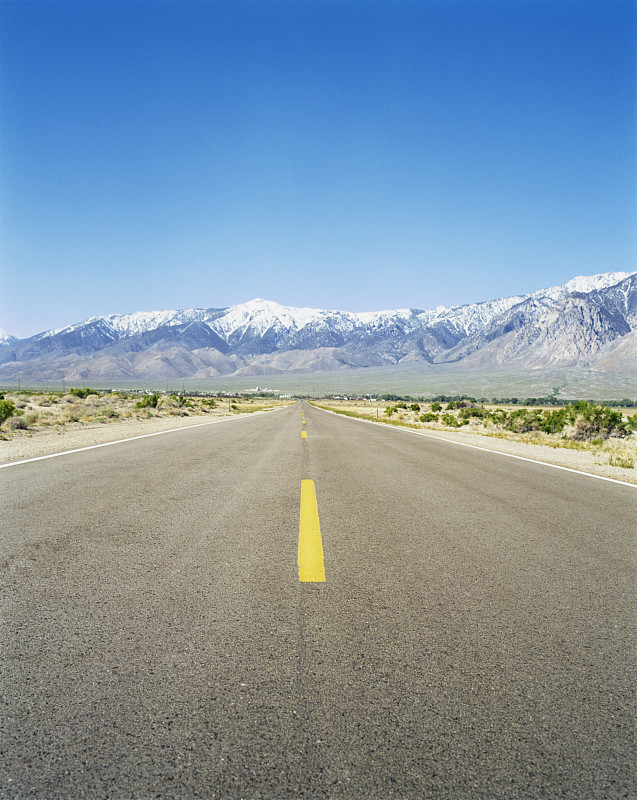 沙漠道路与地平线上的山脉，欧文斯湖，加利福尼亚州图片素材