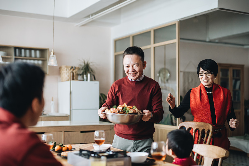 三代欢乐的亚洲家庭庆祝春节，祖父母在团圆饭上享用传统的中国菜图片下载