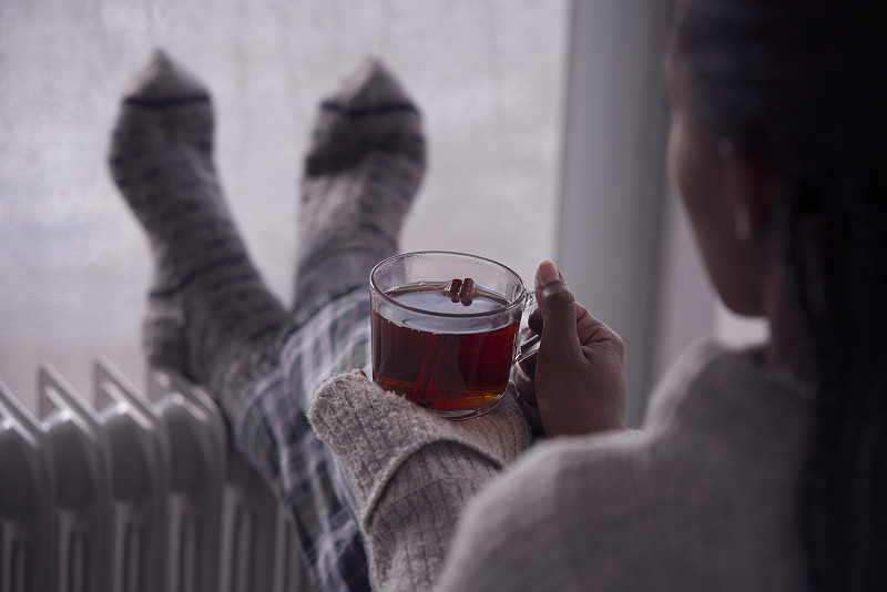 后面是一个女人在阴冷潮湿的天气在家喝茶的画面。图片素材