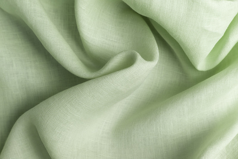用大麻和绿叶制成的纺织品。织物作为背景，织物有波浪褶皱。图片下载