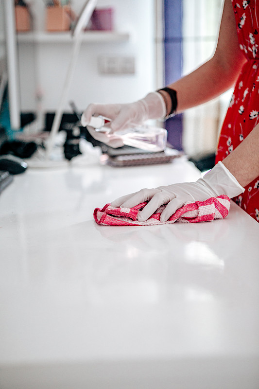 女性用橡胶手套擦拭表面。图片下载
