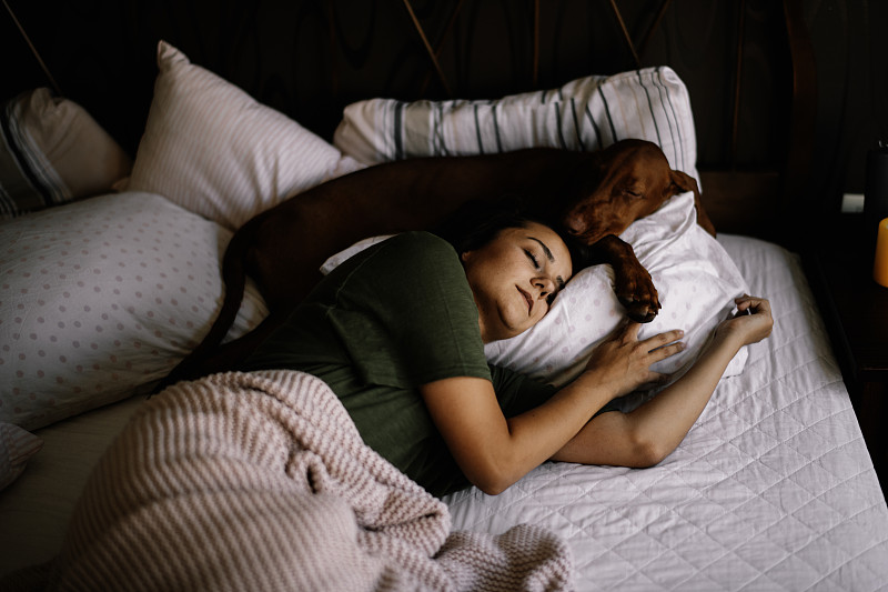女孩和她的狗睡觉。图片下载