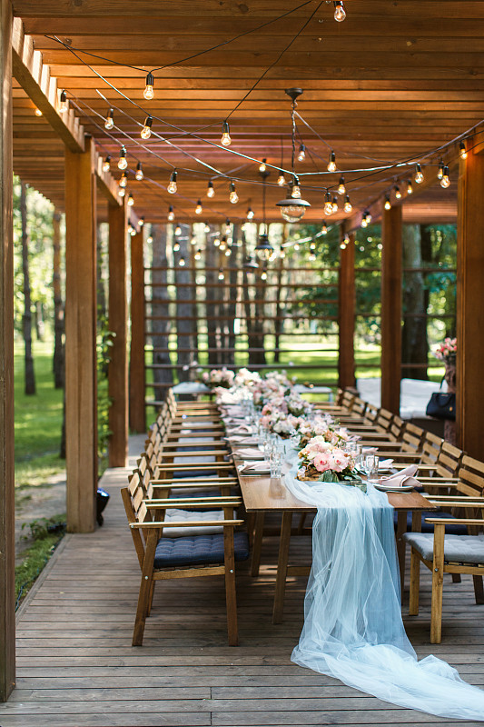 森林里一家餐厅阳台上的一张质朴的婚礼餐桌图片素材