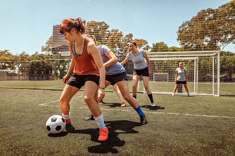 中年妇女在球场上踢足球图片素材