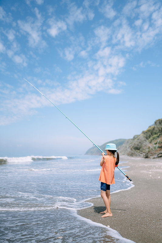 小女孩在东京湾的海滩上钓鱼图片素材