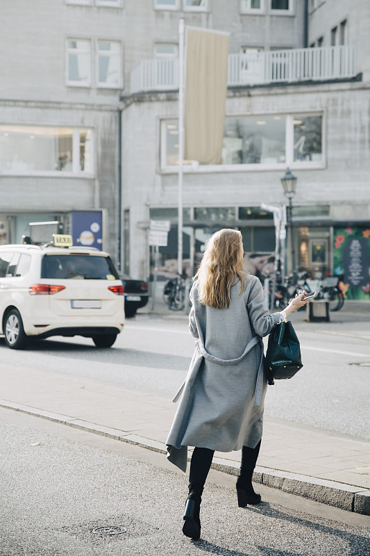 女企业家在城市中行走的后视图图片素材