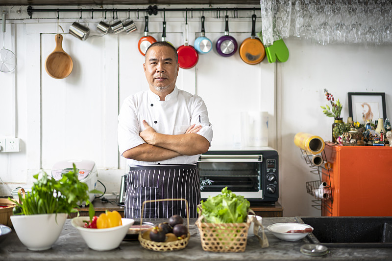 一个亚洲中年男性厨师在厨房图片素材