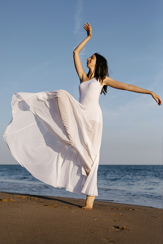 穿着白色裙子的芭蕾舞者在海上跳舞图片素材