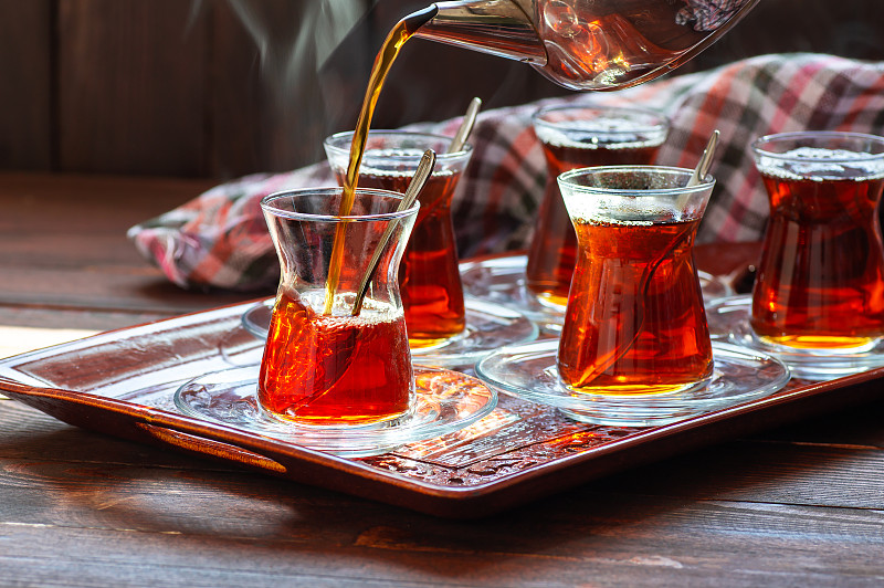 一杯由茶壶倒出的土耳其红茶，传统的热饮概念图片下载