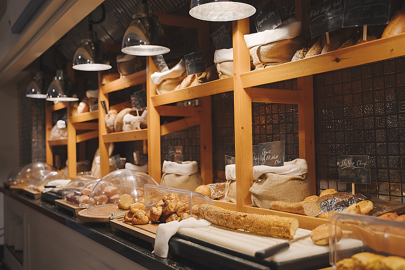 各种新鲜的自制面包和面包店角落在豪华酒店自助早餐，餐厅内部图片素材