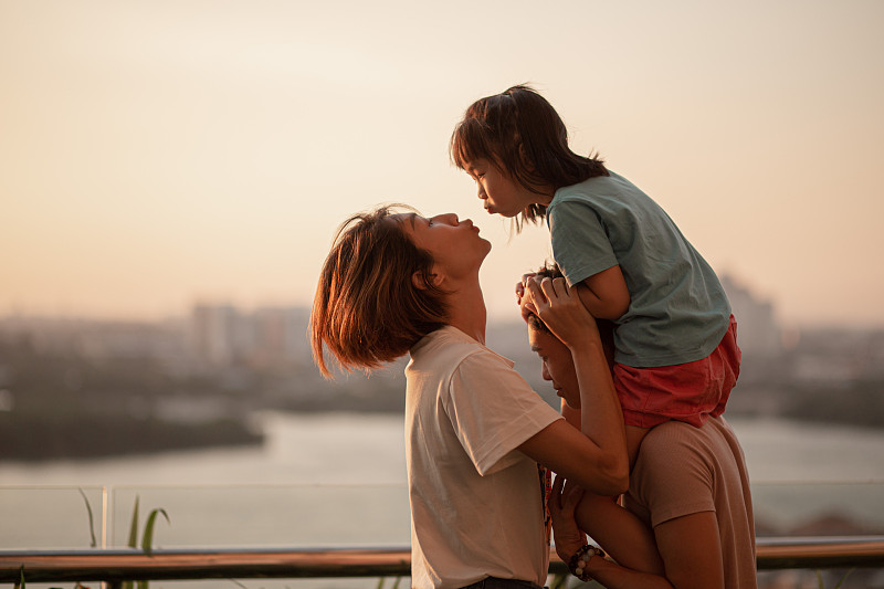 一个亚洲华人家庭和一个孩子在户外欣赏春天的日落美景。图片下载