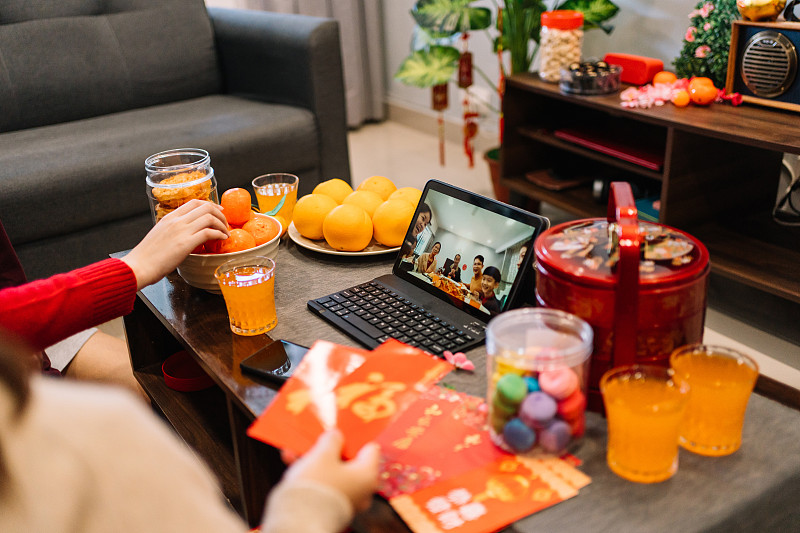 在客厅用电子平板电脑进行视频通话的中国新年聚会图片下载