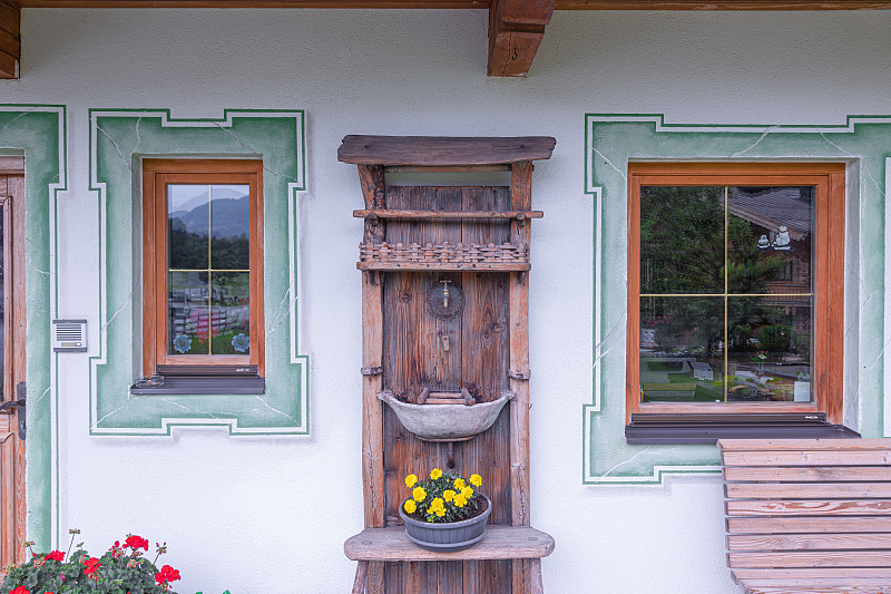 传统的奥地利乡村别墅，装饰有窗户和木制盥洗台。奥地利蒂罗尔摄影图片