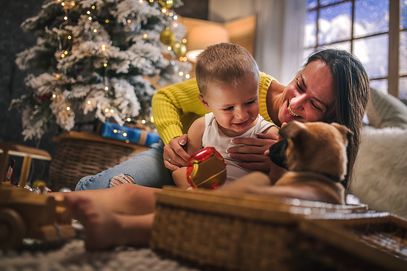 快乐的妈妈和小儿子装饰圣诞树，打开礼物图片下载