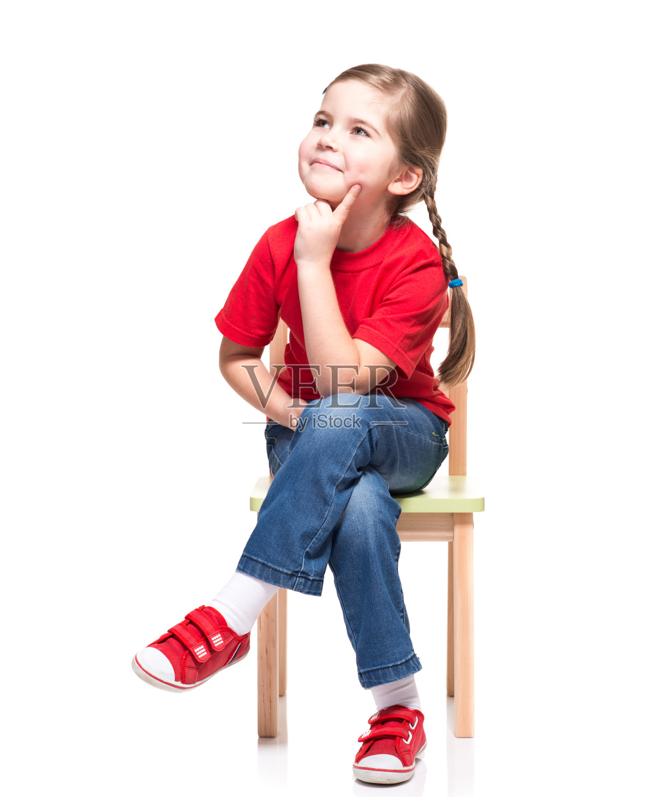 小女孩穿着红色t短裤，在椅子上摆姿势照片摄影图片