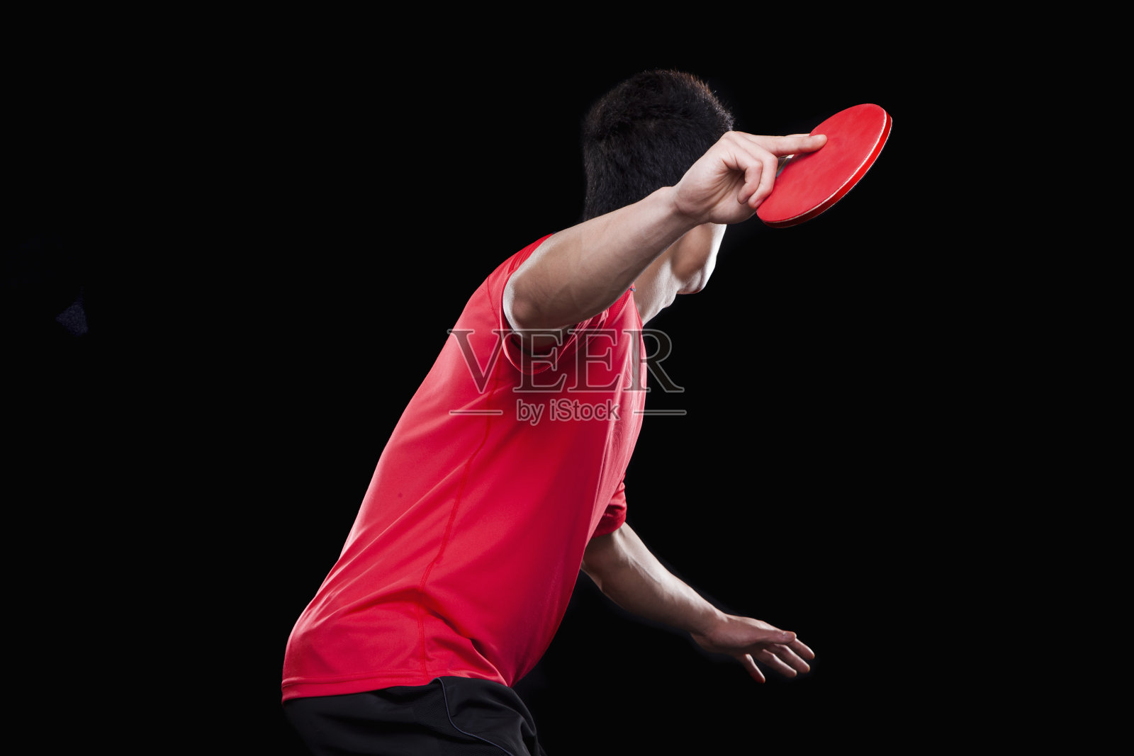 男人在打乒乓球，黑色背景照片摄影图片