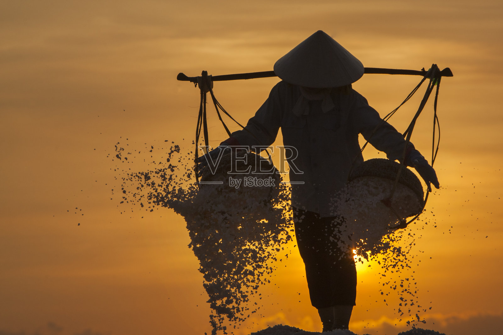 越南，在盐田里劳作的农民照片摄影图片